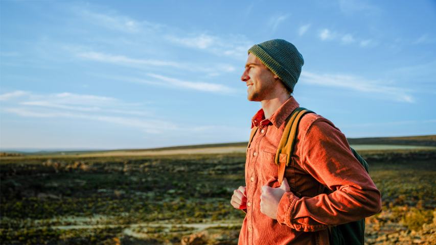 male hiker walking through wilderness