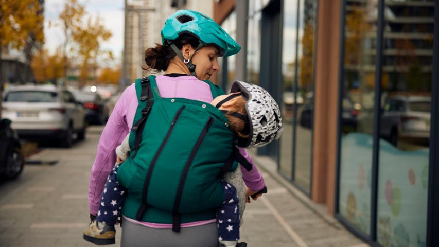 mum cycling with child on her back
